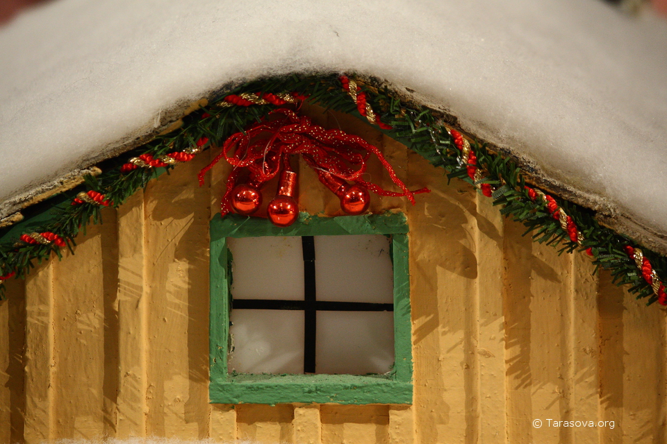 Крупным планом фрагмент домика – окно, украшения и снежная крыша