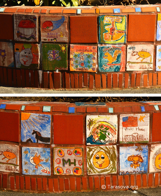 Клумба на перекрестке украшена керамическими плитками с рисунками детей